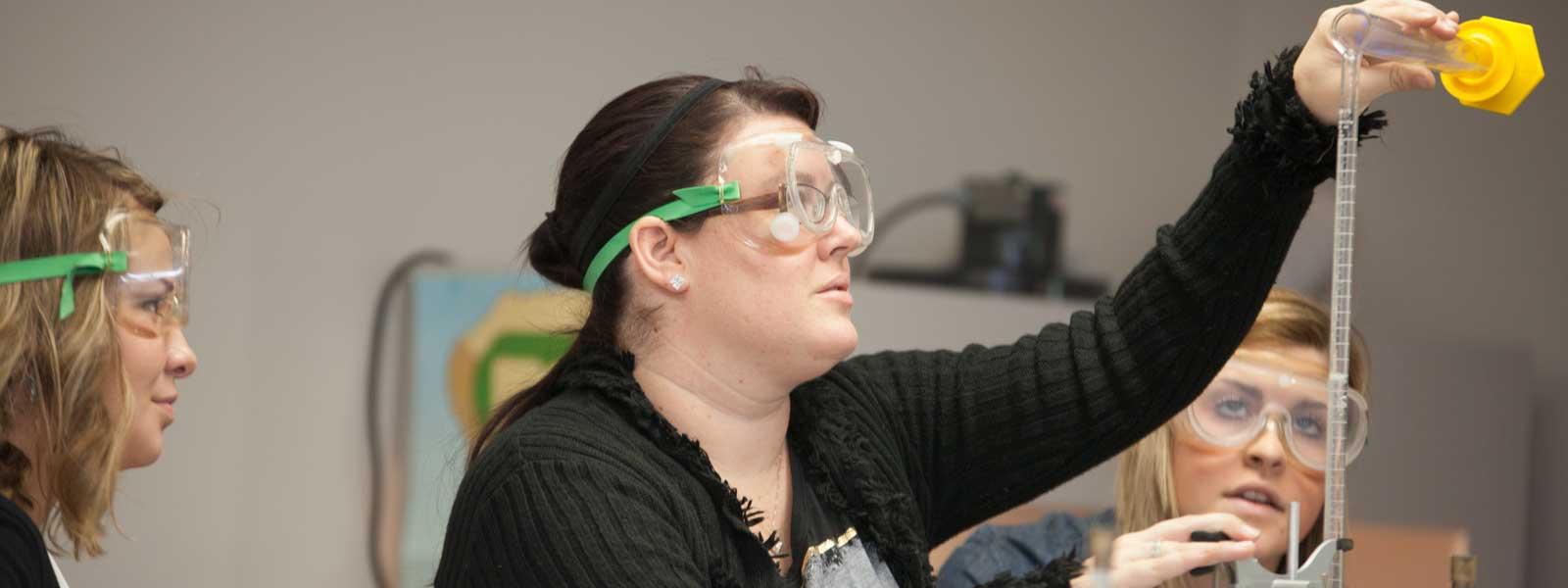 student works on chemistry experiment wearing goggles